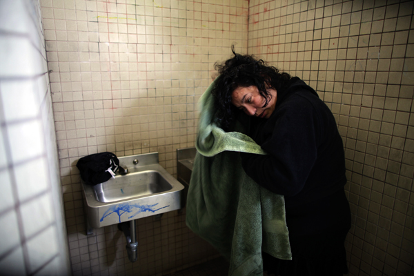 Benita Guzman, 40, washes her hair in the sink of a public restroom after dropping her children at school in Port Hueneme